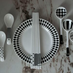 A table with a plate, spoons, and utensils on it